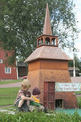 Meine zwei Zwerge vor einer Holzkirche